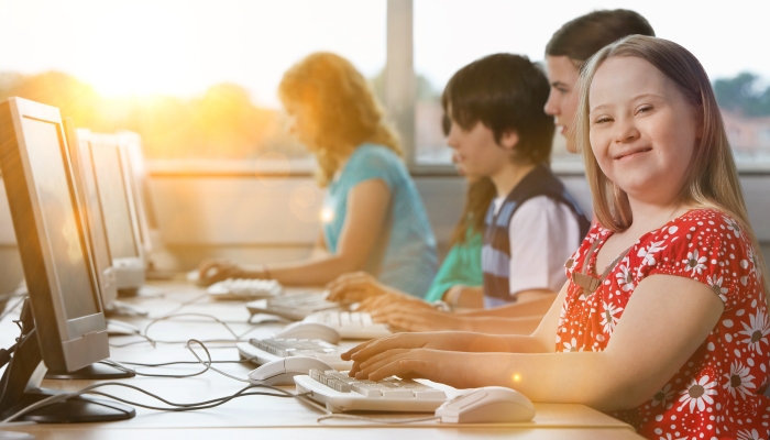 Girl with Down syndrome using computer at school.