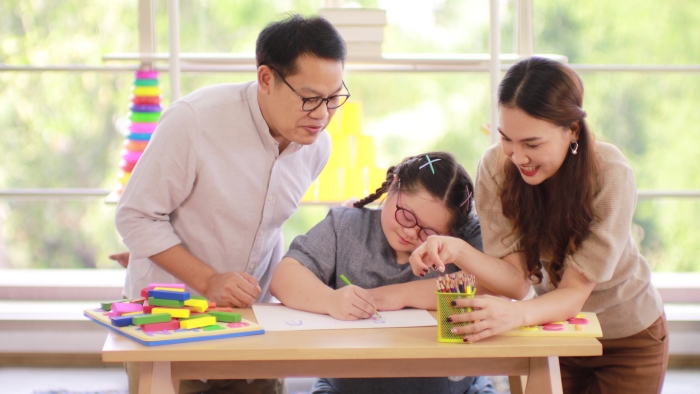 Happy family, dad mom daughter with down syndrome.