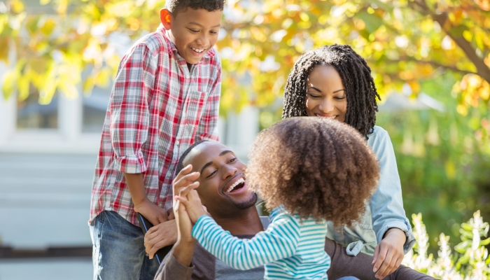 Happy family laughing outdoors together.