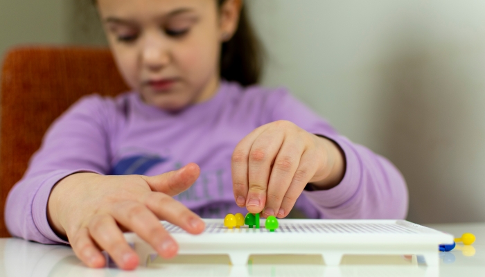 A blind child develops fine motor skills.