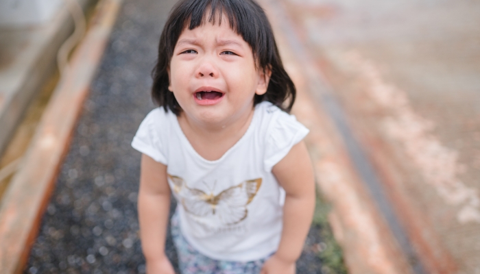 Little asian girl fall on street and crying.