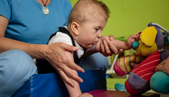 Portrait of a baby with cerebral palsy on physiotherapy in a children therapy center.