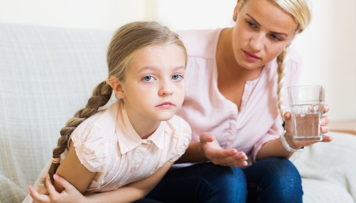 Portrait of concerned woman and child with abdominal pains.