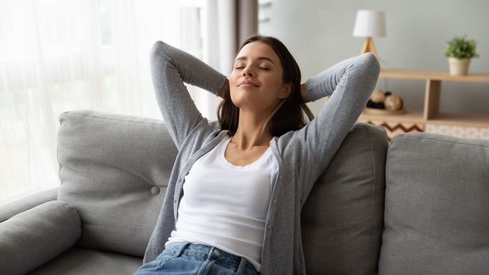 Relaxed serene pretty young woman feel fatigue lounge on comfortable sofa.