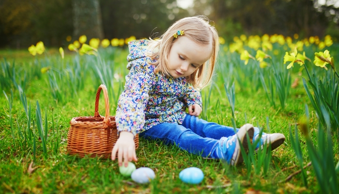 Three year old girl playing egg hunt on Easter.