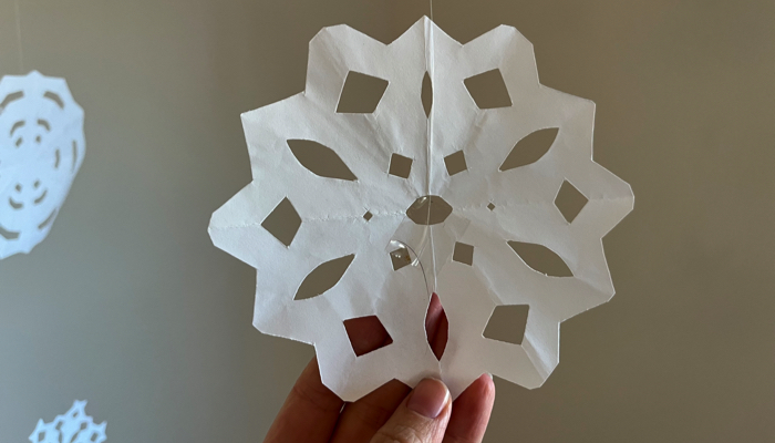 Close up of a hanging paper snowflake.