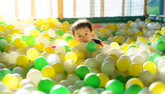 Adorable Asian boy in colorful balls.