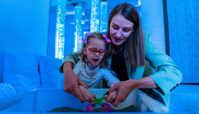 Child with physical disability in sensory stimulating room, snoezelen.