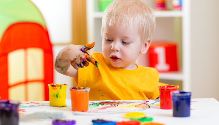 Cute kid boy painting at home or playschool.