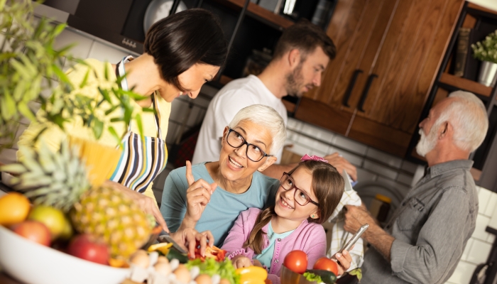 Family with grandparent preparing meal, everyone in the kitchen together.