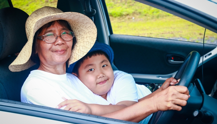 Grandma and granddaughter drive car.