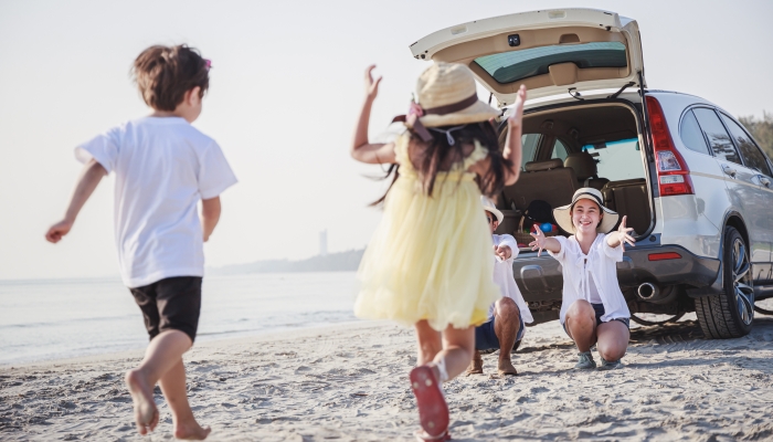 Happy family with children playing together on a tropical beach during the summer holidays.