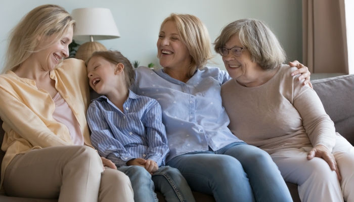 Joyful happy girls and women of different ages laughing, talking, chatting, resting on couch at home.