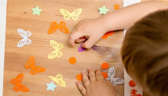 Kid making a window decoration.