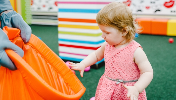 Little cute fun child on birthday party in kids amusement park and play center indoor.