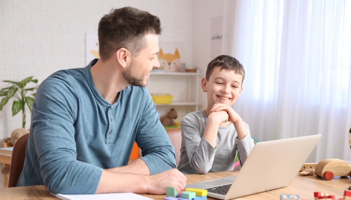 Father talking with his autistic boy in his office.