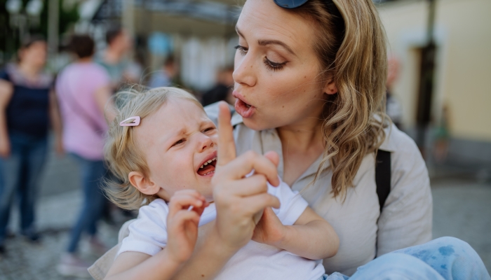 Mother scolding her little daughter in street.