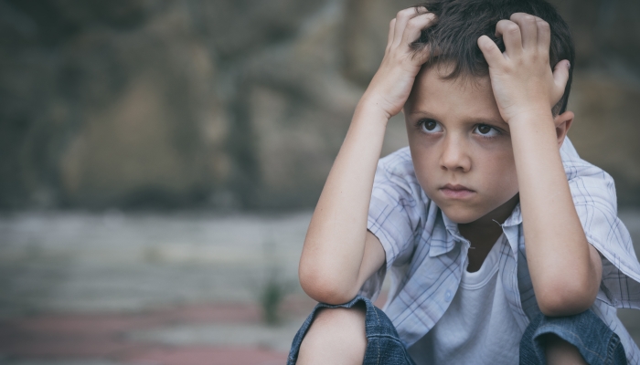 Portrait of sad little boy outdoors at the day time.