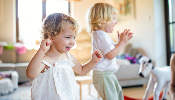 Portrait of small boy and girl playing indoors at home.