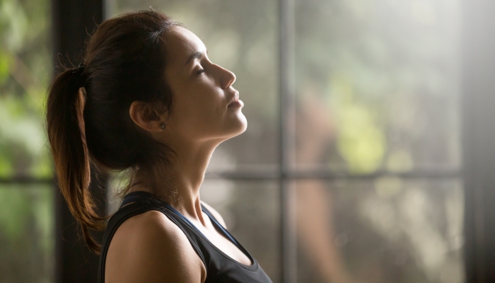 Profile portrait of young attractive yogi woman breathing fresh air.