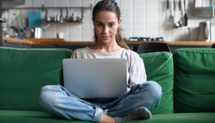 Serious woman using laptop checking email news.