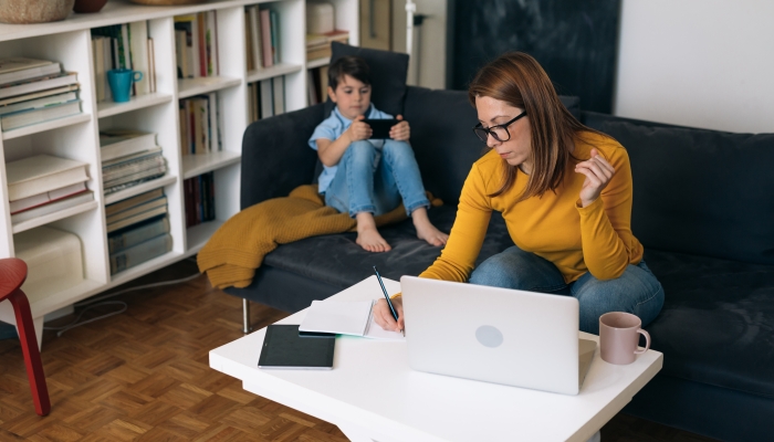 She sits in living room and her son is beside her.