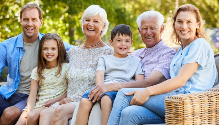 Three generation family sitting together in the garden.