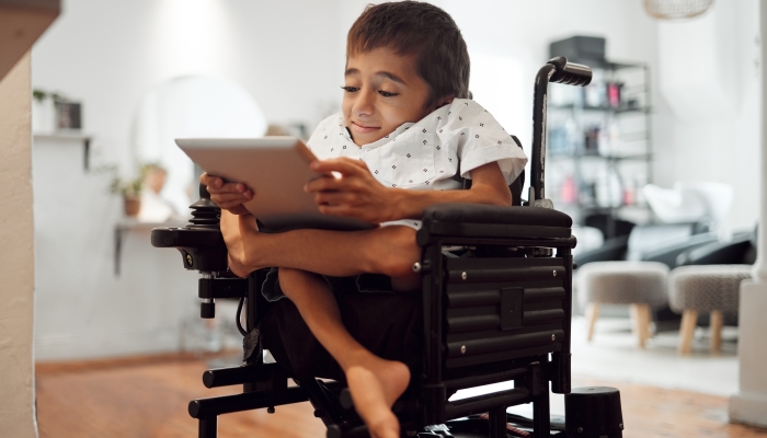 Wheelchair, disability and child with tablet for learning.