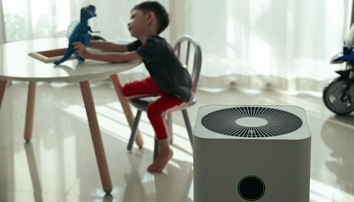 Air purifier in living room with kid playing inside home.