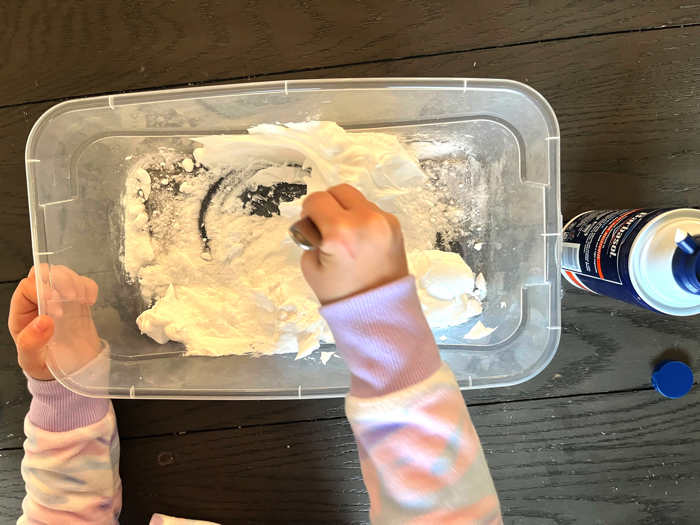 Playing with a snowy animals sensory bin.