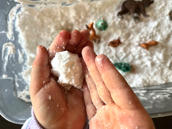 Playing with a snowy animals sensory bin.