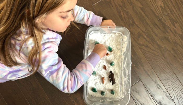 Playing with a snowy animals sensory bin.