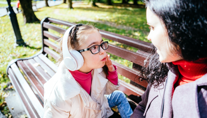 Charming caucasian mother communicating with her little girl with special needs in googles.