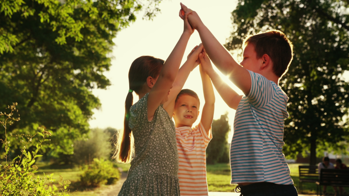 Childrens teamwork, group of children play in park.