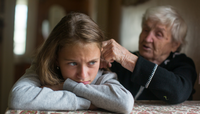 Elderly woman is spending time with her disgruntled granddaughter.