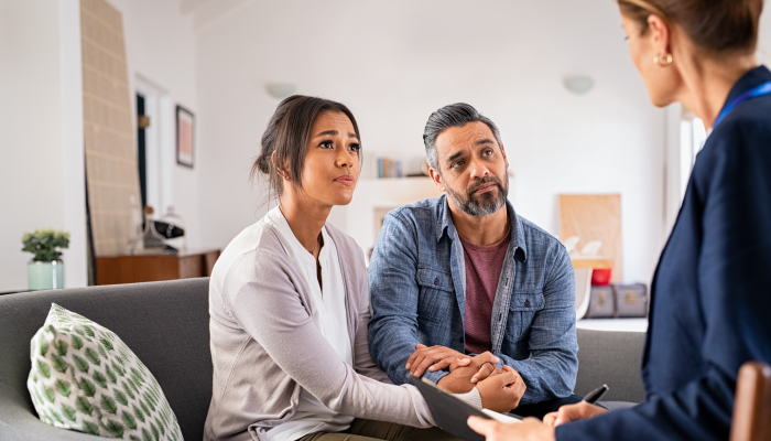 Mature stressed married couple and talking to advisor at home.