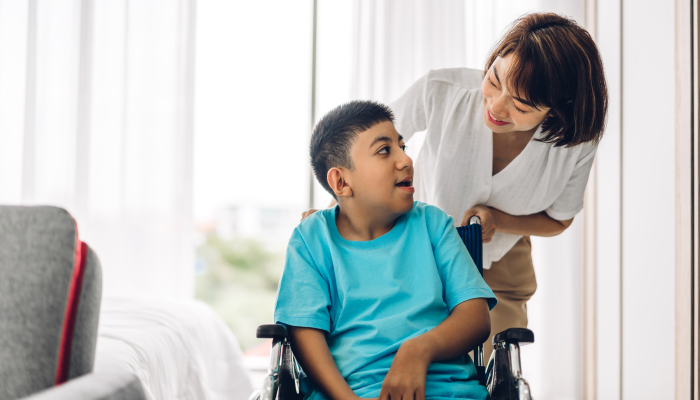 Portrait of enjoy happy love family asian mother playing and carer helping look at disabled son.