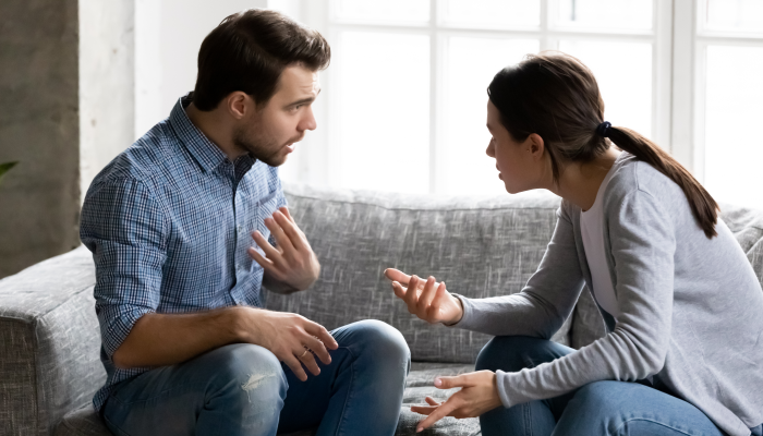 Stressed young married family couple arguing emotionally.