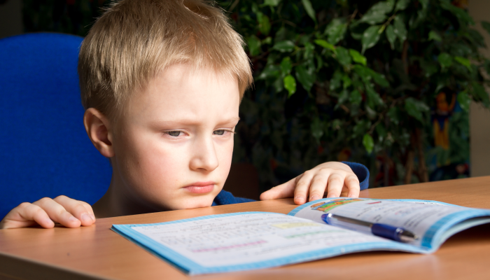 Tired boring boy don't want to do his difficult school homework.