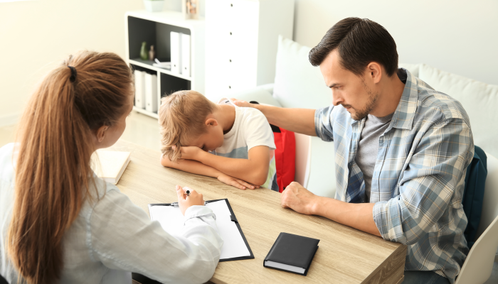 Young man and his son meeting with headmistress at school.