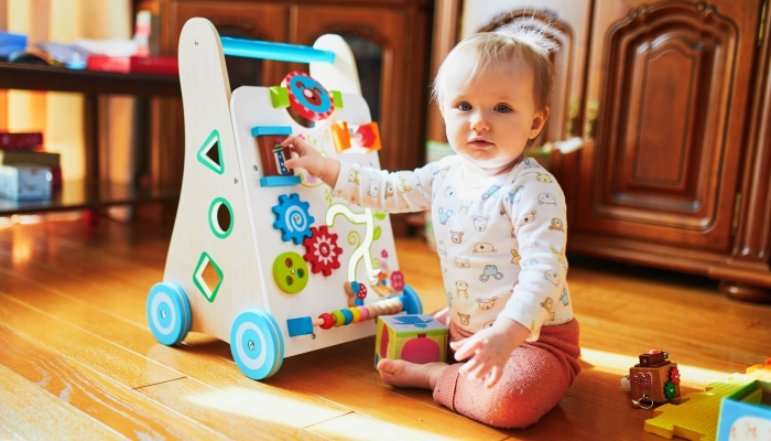 Adorable toddler with baby-walker.