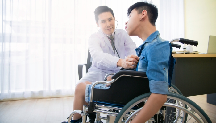 Asian doctor use stethoscope checkup disability wheel chair patient person.