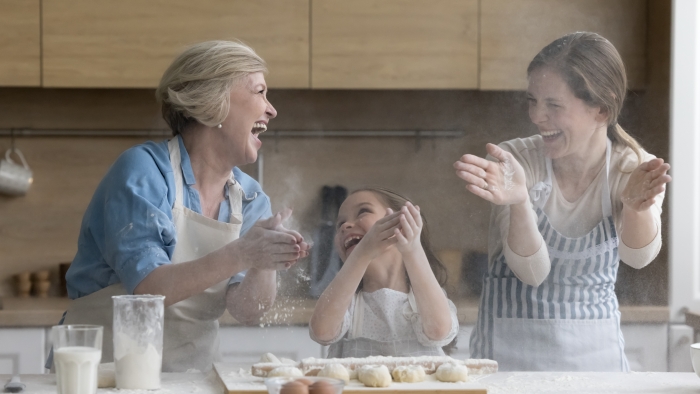 Cheerful overjoyed kid, mother and grandma having fun in kitchen.