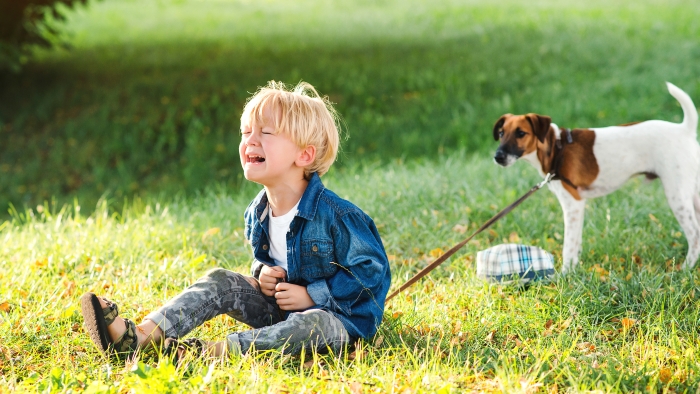 Little boy crying and sitting on the ground.