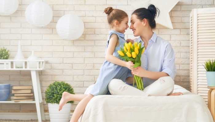 Mum and girl smiling and hugging.