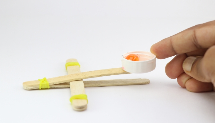 Popsicle stick model of a catapult made using recycled materials.