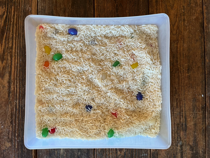 Jelly Bean Sensory Bin and Color Sorting with the jelly beans hidden in the rice.