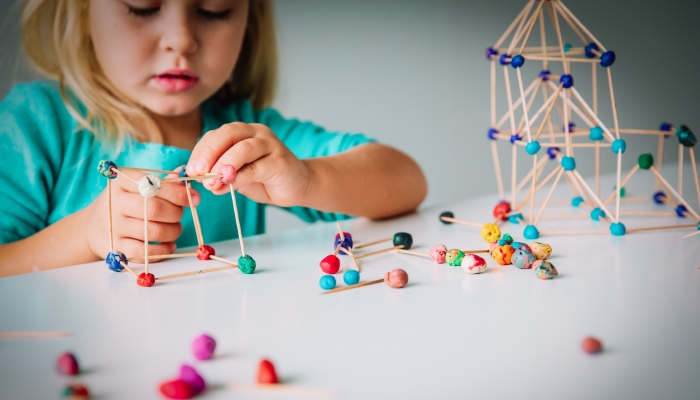 Little girl making geometric shapes, engineering and STEM.