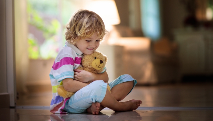 Child playing with teddy bear.